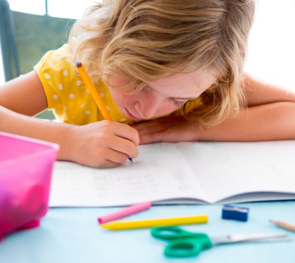 Child student kid girl writing with homework on desk table